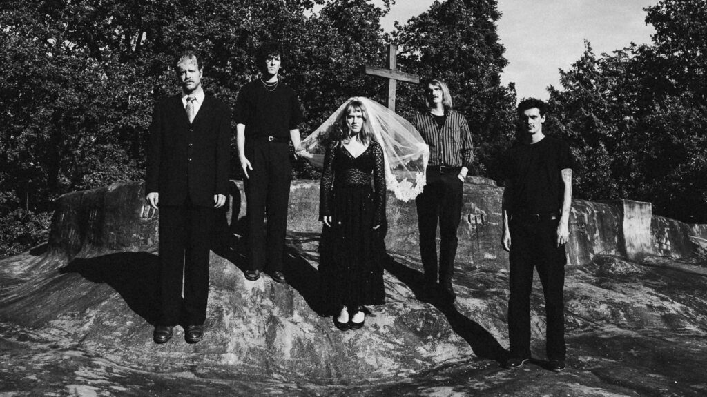 Postpunk Band De Mis is posing in front of a graveyard
