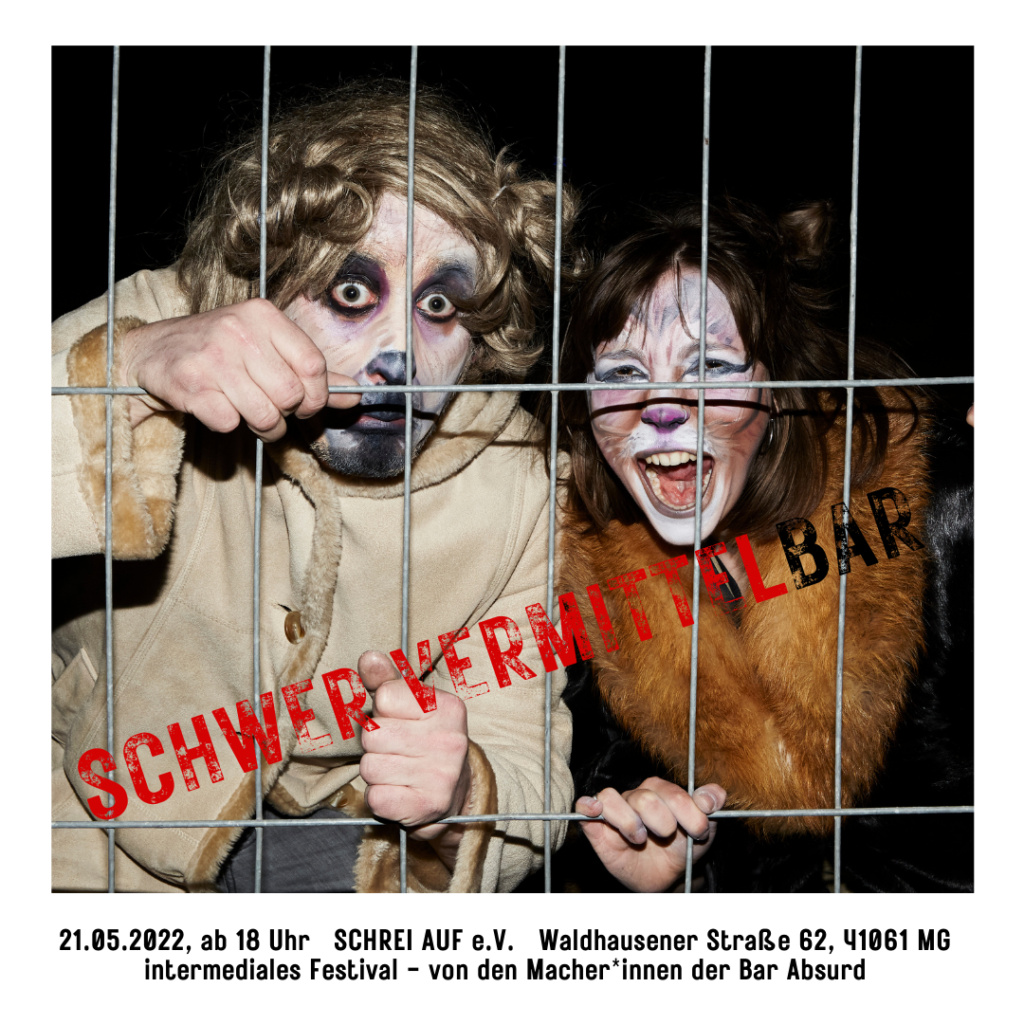 Zwei Menschen sind je als Hund und als Katze verkleidet und sitzen hinter einem Gitterzaun. Der Hund schaut sehr traurig. Die Katze faucht aggressiv.